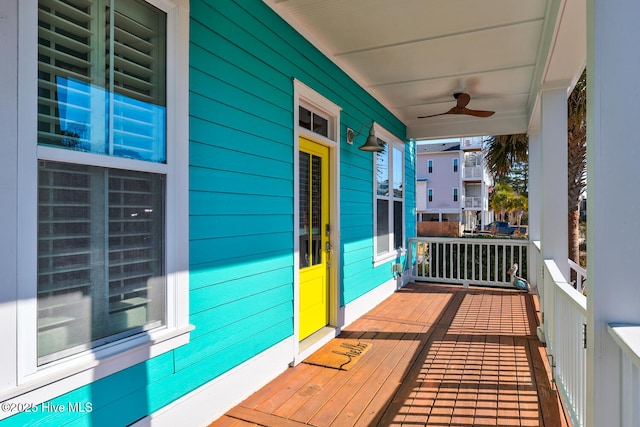 wooden deck featuring covered porch and ceiling fan