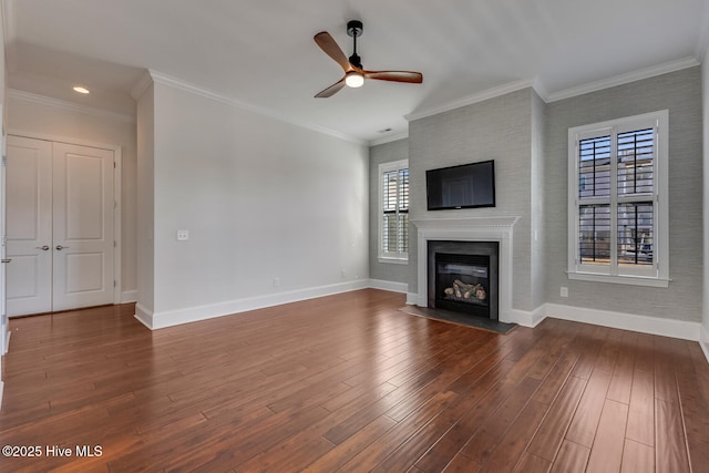 unfurnished living room featuring ceiling fan, dark wood-type flooring, ornamental molding, and a fireplace