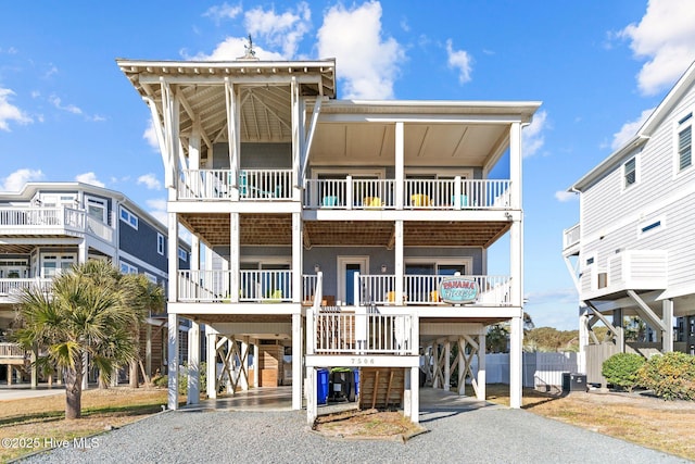 beach home featuring covered porch, central air condition unit, and a carport