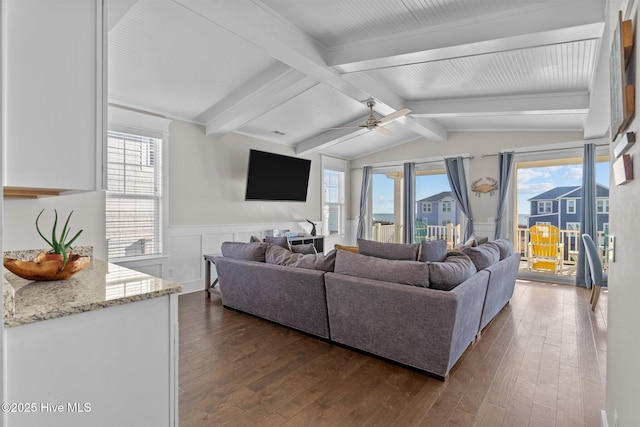 living room with ceiling fan, dark hardwood / wood-style floors, and vaulted ceiling with beams