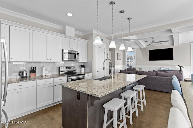 kitchen featuring appliances with stainless steel finishes, sink, white cabinetry, and a center island with sink