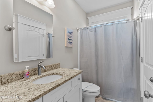 bathroom with toilet, vanity, and walk in shower