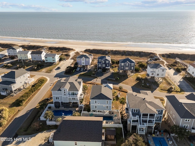 drone / aerial view featuring a water view and a beach view