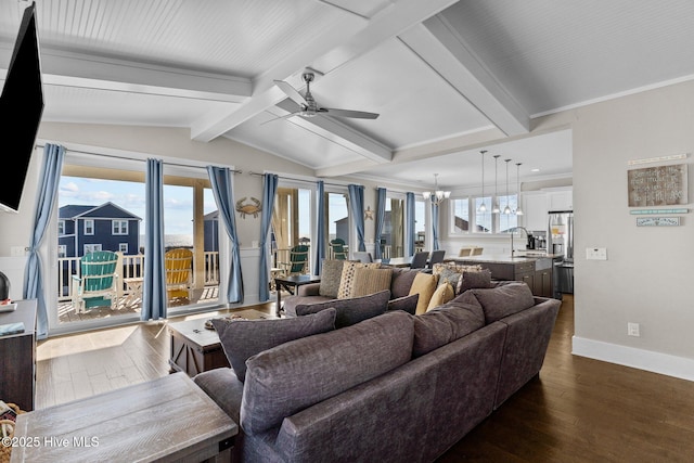 living room with a wealth of natural light, dark hardwood / wood-style floors, sink, and ceiling fan with notable chandelier