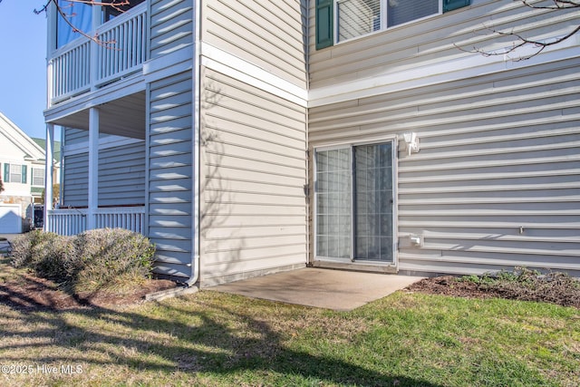 property entrance with a patio and a lawn