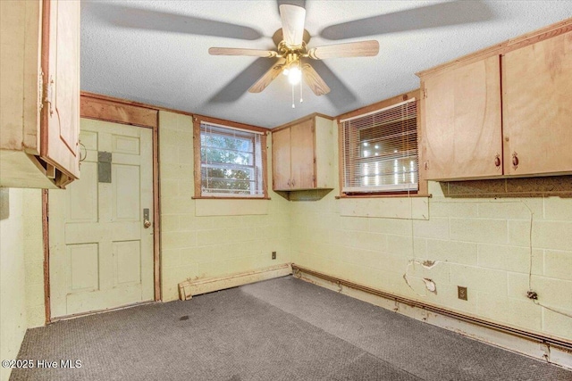 unfurnished room featuring a textured ceiling, ceiling fan, and carpet floors