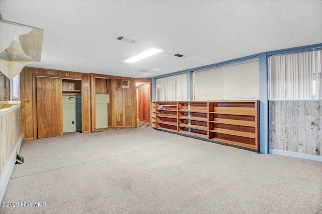 empty room with wood walls and a textured ceiling