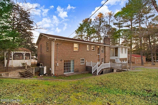 rear view of house featuring central AC, a wooden deck, and a lawn