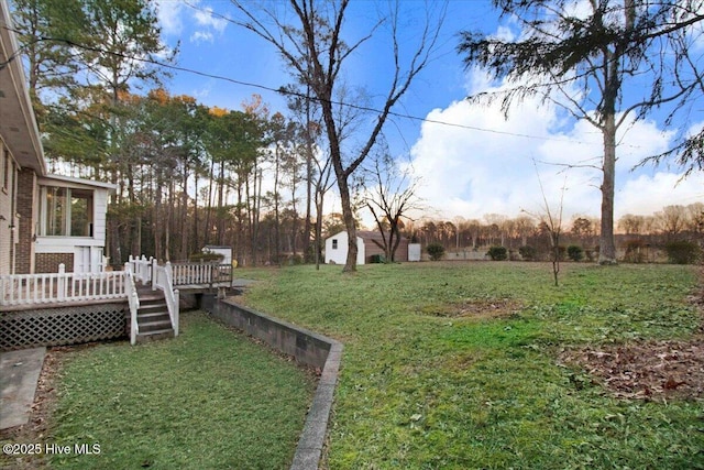 view of yard featuring a storage shed and a wooden deck