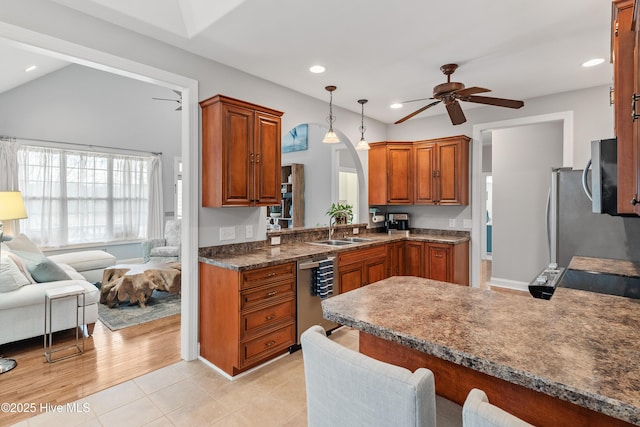 kitchen featuring appliances with stainless steel finishes, hanging light fixtures, kitchen peninsula, ceiling fan, and sink