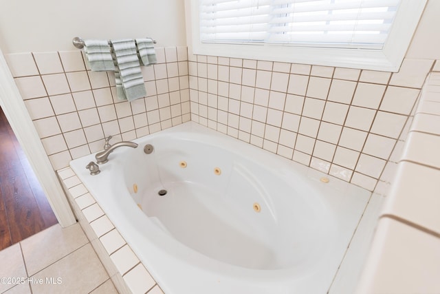 bathroom with tiled tub and tile patterned flooring