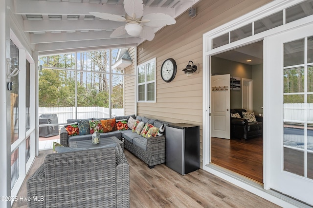 sunroom / solarium with ceiling fan and vaulted ceiling with beams