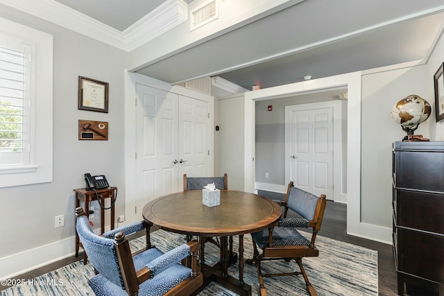 dining space featuring dark hardwood / wood-style floors and ornamental molding