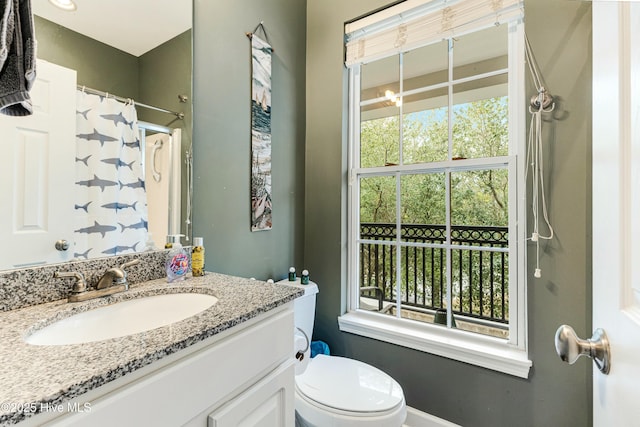 bathroom with toilet, a healthy amount of sunlight, a shower with curtain, and vanity