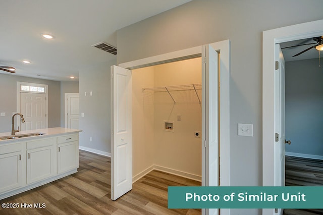 laundry room featuring sink, washer hookup, ceiling fan, and light hardwood / wood-style flooring