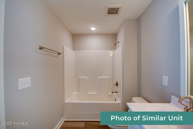 full bathroom with vanity, hardwood / wood-style floors, shower / bathtub combination, and toilet