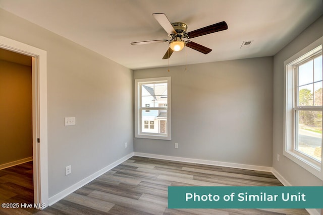 spare room with a ceiling fan, wood finished floors, and baseboards