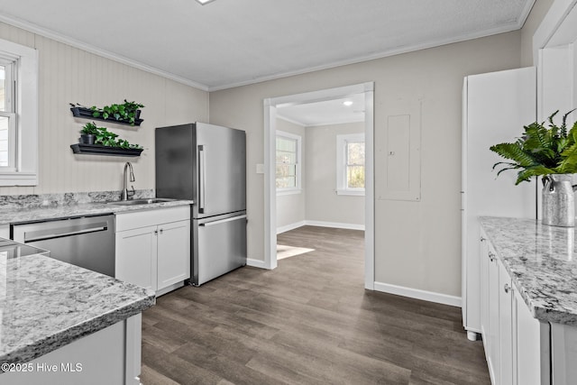 kitchen with sink, stainless steel appliances, ornamental molding, and white cabinetry