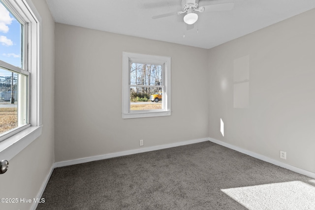 carpeted empty room featuring ceiling fan and a wealth of natural light