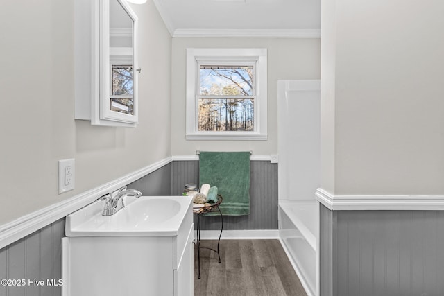 bathroom with ornamental molding, a bathtub, vanity, and hardwood / wood-style flooring