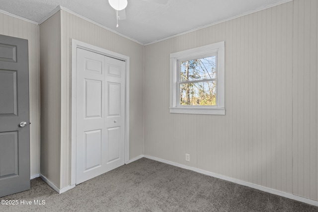 unfurnished bedroom featuring light carpet, a closet, ceiling fan, and crown molding