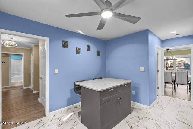 kitchen with ceiling fan with notable chandelier and a kitchen island