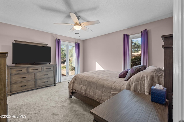 carpeted bedroom with ceiling fan and a textured ceiling