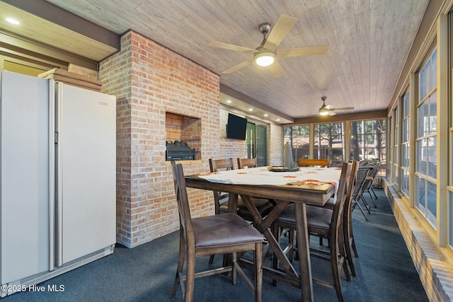 sunroom featuring ceiling fan and wood ceiling