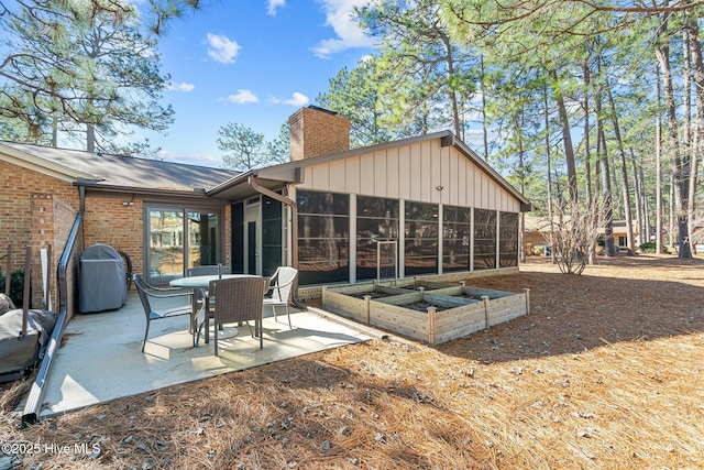 rear view of house featuring a patio and a sunroom