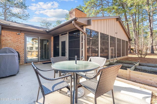 view of patio featuring a sunroom and a grill