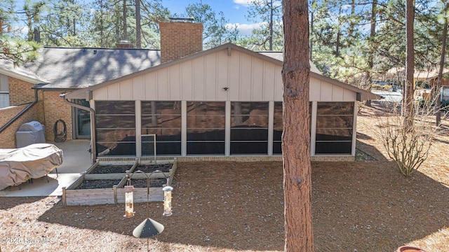 back of property with a sunroom and a patio