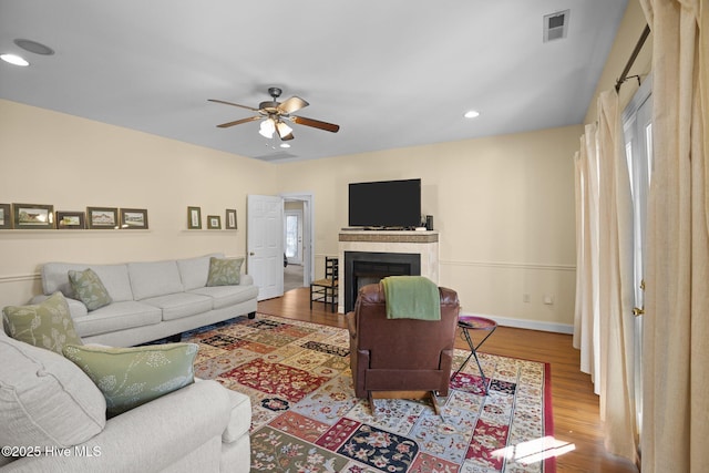 living room featuring ceiling fan and hardwood / wood-style flooring