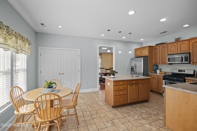 kitchen with a healthy amount of sunlight, stainless steel appliances, a center island, and hanging light fixtures