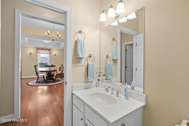 bathroom with vanity, hardwood / wood-style floors, and a notable chandelier