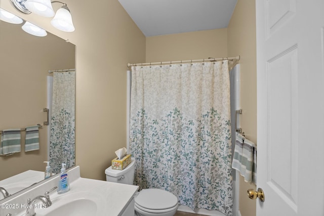 bathroom with walk in shower, vanity, and toilet