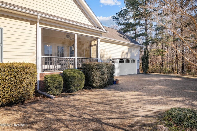 view of side of home featuring ceiling fan, a garage, and covered porch