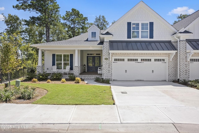 view of front of house with a porch, a front lawn, and a garage