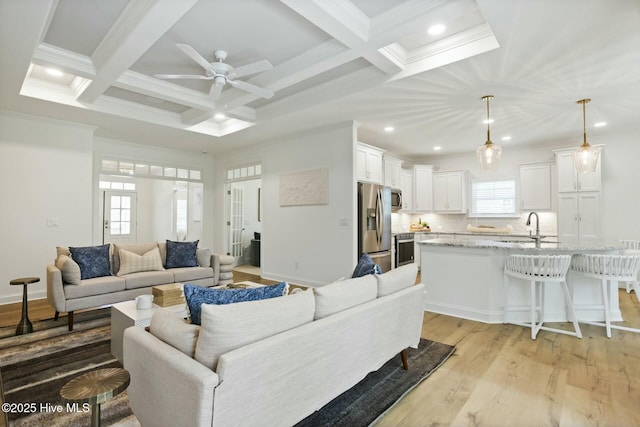 living room with coffered ceiling, ceiling fan, and beam ceiling