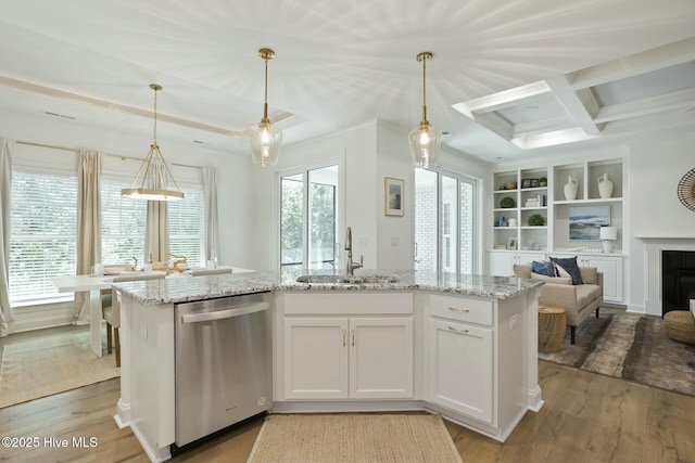 kitchen featuring sink, white cabinets, light hardwood / wood-style floors, stainless steel dishwasher, and pendant lighting