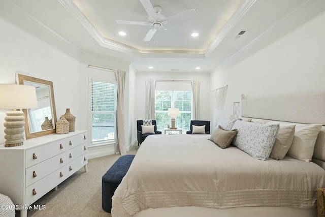 carpeted bedroom with ceiling fan, a tray ceiling, and crown molding