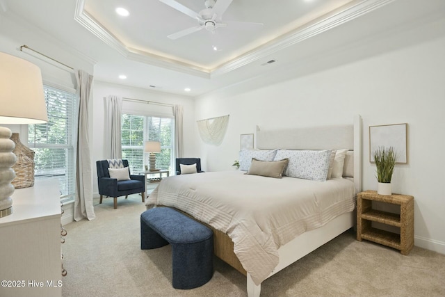 carpeted bedroom with crown molding, ceiling fan, and a tray ceiling