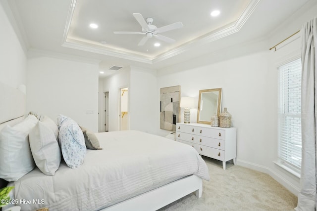 carpeted bedroom with ornamental molding, ceiling fan, and a tray ceiling