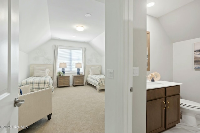 bedroom with sink, vaulted ceiling, and light colored carpet