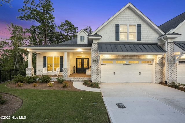 view of front of home featuring a porch, a lawn, and a garage