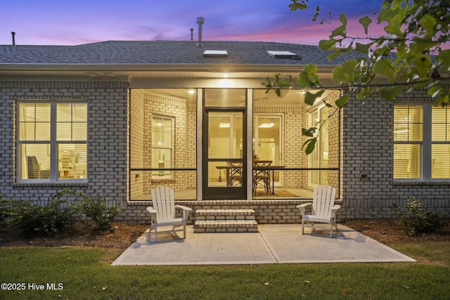 exterior entry at dusk featuring a patio