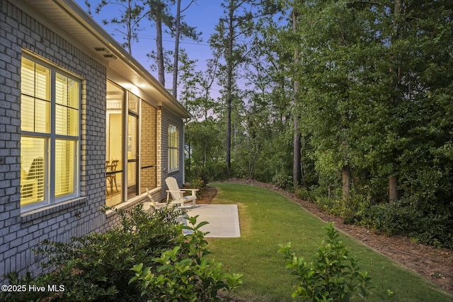 yard at dusk featuring a patio area