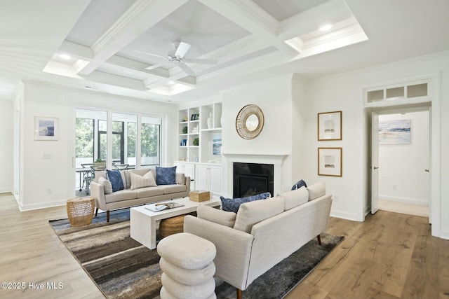 living room with coffered ceiling, crown molding, beamed ceiling, ceiling fan, and light hardwood / wood-style flooring