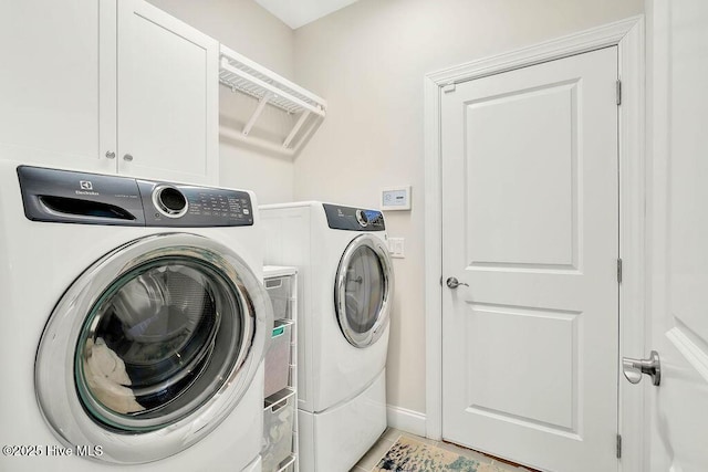 washroom with tile patterned flooring, separate washer and dryer, and cabinets