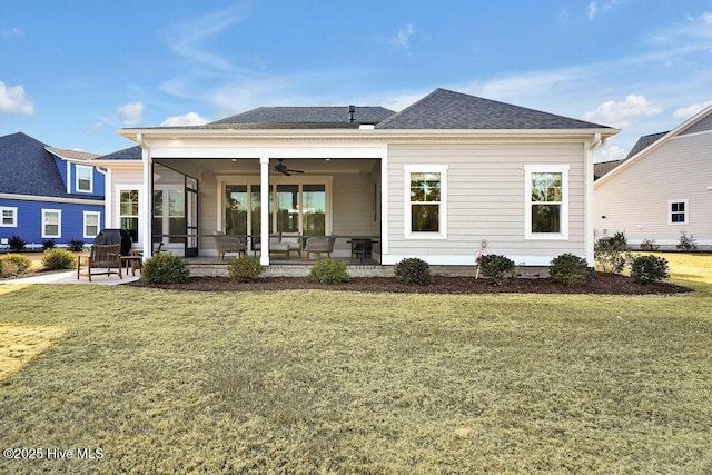 rear view of property featuring ceiling fan, a yard, and a patio