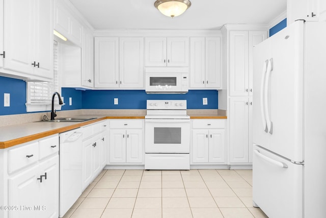 kitchen with sink, white appliances, and white cabinetry